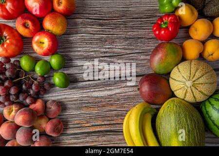 Saisonales Obst und Gemüse auf Holzplanke. Rote Äpfel, Pfirsiche und Paraguayaner, rote Limetten und Trauben, Bananen und Melonen, Tomaten und Wassermelone Stockfoto