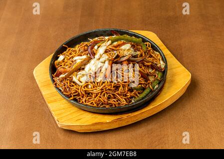 Sautierte Nudeln mit Gemüse und Yakisoba-Sauce auf einem Holztisch Stockfoto