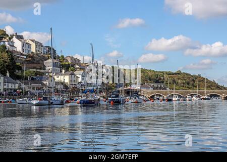 Boote auf dem Fluss Looe in der Nähe der Brücke. Die Häuser am Hang bei West Looe bieten den Hintergrund. Looe Cornwall. Stockfoto