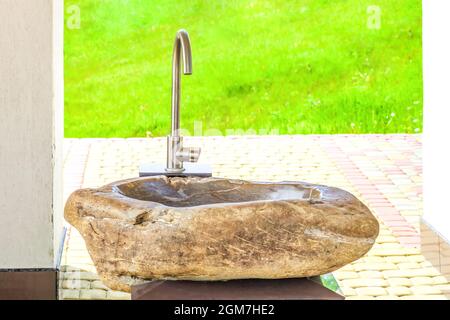 Waschbecken aus Stein im Hof. Modernes Waschbecken im Sommerhinterhof bei sonnigem Licht, Vorderansicht Stockfoto