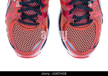 Rote Laufschuhe mit schwarzen Schnürsenkeln auf weißem Hintergrund Stockfoto