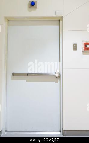 Notausgang des Gebäudes mit Ausstiegsschild an der Tür und Feuerlöscher an der Außenseite eines Gebäudes Stockfoto