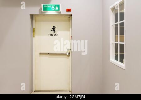 Notausgang des Gebäudes mit Ausstiegsschild an der Tür und Feuerlöscher an der Außenseite eines Gebäudes Stockfoto