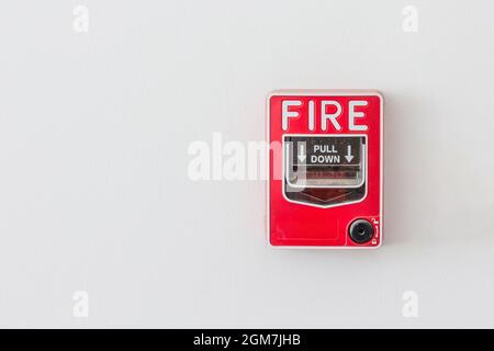 Feueralarm-Schalter an weißer Wand als Hintergrund für Warn- und Sicherheitssystem mit Kopierraum und Text. Stockfoto