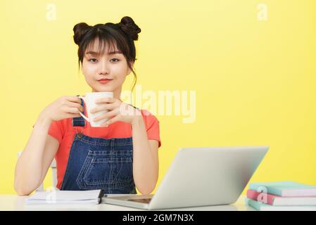 Weibliche College-Student trinken Tasse Kaffee, bevor sie Online-Klasse Stockfoto