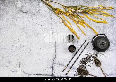 Bild von schwarzem japanischer Tee-Service mit Blumen und Essstäbchen auf weißem Hintergrund Stockfoto