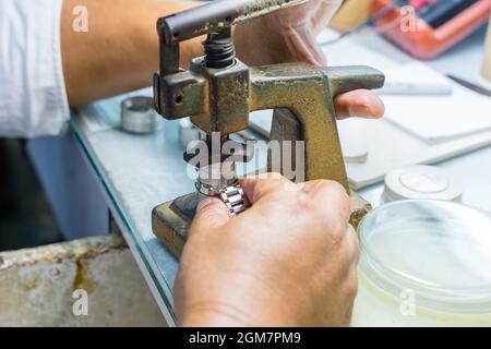 Leitender Uhrmacher, der eine alte Taschenuhr repariert Stockfoto