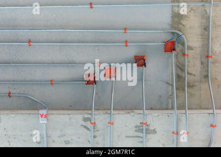 Stahlrohre für die Installation von Elektroverteilungssystemen an der Decke im neuen Gebäude Stockfoto