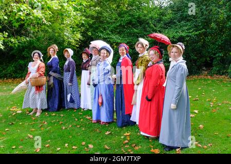 Jane Austen-Enthusiasten in Regency-Kostümen machen eine Prozession durch die Stadt. Das jährliche Festival zieht Austen-Enthusiasten aus der ganzen W an Stockfoto