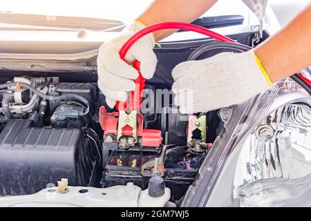 Laden Autobatterie mit Strom Trog Starthilfekabel, rote und schwarze Starthilfekabel Stockfoto