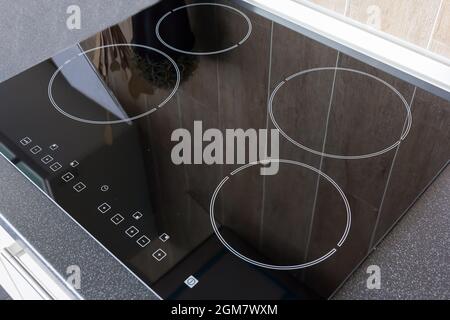 Nahaufnahme einer elektrischen Küche Induktions-Keramik-Kochfeld mit Küchenmöbeln Stockfoto