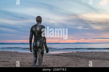 Die Flut, die im September 2021 am Crosby Beach in der Nähe von Liverpool eingeht, als sie sich einem Iron man nähert, der Teil von Antony Gormleys Another Place Art i ist Stockfoto