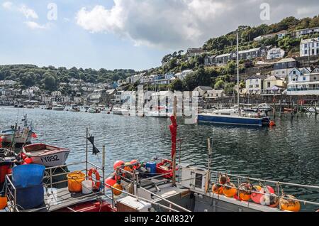 Die terrassenförmig angelegten Häuser, Hotels und Bars von West Looe bilden die Kulisse für die Boote auf dem Fluss Looe. Looe Cornwall. Stockfoto