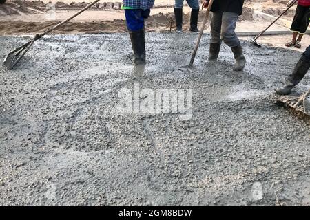 Arbeiter, die Stahlbetonböden vor Ort gießen Stockfoto