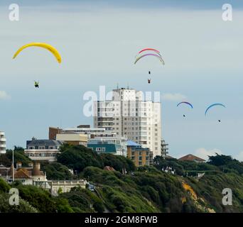 Bournemouth, Dorset, Großbritannien. September 2021. Wetter in Großbritannien. Gleitschirme fliegen an einem Tag mit warmer, trüber Herbstsonne über den Klippen über dem Bournemouth Beach in Dorset. Bildnachweis: Graham Hunt/Alamy Live News Stockfoto