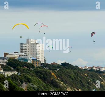 Bournemouth, Dorset, Großbritannien. September 2021. Wetter in Großbritannien. Gleitschirme fliegen an einem Tag mit warmer, trüber Herbstsonne über den Klippen über dem Bournemouth Beach in Dorset. Bildnachweis: Graham Hunt/Alamy Live News Stockfoto