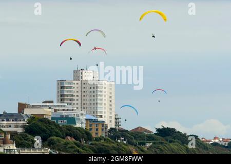 Bournemouth, Dorset, Großbritannien. September 2021. Wetter in Großbritannien. Gleitschirme fliegen an einem Tag mit warmer, trüber Herbstsonne über den Klippen über dem Bournemouth Beach in Dorset. Bildnachweis: Graham Hunt/Alamy Live News Stockfoto