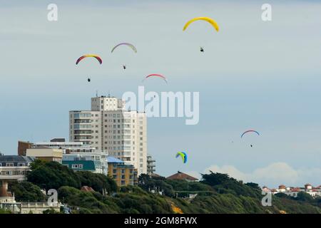 Bournemouth, Dorset, Großbritannien. September 2021. Wetter in Großbritannien. Gleitschirme fliegen an einem Tag mit warmer, trüber Herbstsonne über den Klippen über dem Bournemouth Beach in Dorset. Bildnachweis: Graham Hunt/Alamy Live News Stockfoto