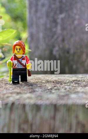 GREENVILLE, USA - 29. Aug 2021: Eine vertikale Nahaufnahme einer LEGO-Figur auf einem Stein im Freien in Greenville, USA Stockfoto