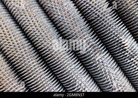 Verflüssigungssatz Aluminium Closeup veraltete Rohre Grill diagonale Textur, Kompressor und Klimaanlage. Industrielles Hintergrundmetall Stockfoto