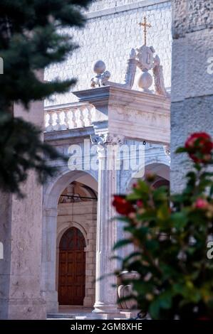 Goldenes Kreuz und korinthische kannelierte Säulen des Wasserbrunnens in der Abtei Montecassino in Italien. Stockfoto