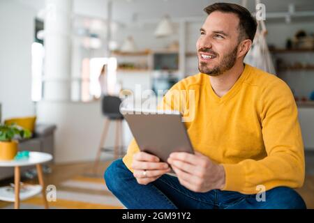 Porträt eines hübschen jungen glücklichen Mannes mit digitalem Tablet Stockfoto