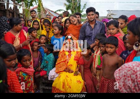 Mongla, Bangladesch. September 2021. Ein 14-jähriges Schulmädchen Hafsa sitzt mit Freunden und Nachbarn, während sie an ihrem Hochzeitstag in einem Dorf namens Joymoni aus einem Küstengebiet von Mongla im Bezirk Bagerhat für Fotos posiert.Bangladesch erlebte im vergangenen Jahr einen 13%igen Anstieg der Kinderheiraten während der Covid-19-Pandemie als die tödliche Das Virus hat Gesellschaften und Volkswirtschaften massiv getroffen und viele in extreme Armut getrieben. Die Abteilung für Geschlechtergerechtigkeit und Diversität von Brac, der weltweit größten NGO, fand heraus, dass die Kinderehe um 13 % gestiegen ist, als sie eine Umfrage durchführte, um auf die Auswirkungen des C zuzugreifen Stockfoto