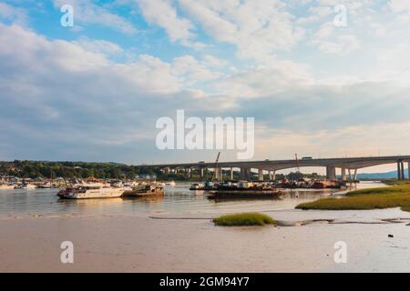 Low Tide, am späten Nachmittag Medway Estuary in Rochester in Kent mit Bootsreparatoren schwimmende Dock im Bild mit M2 Medway Bridge im Hintergrund Stockfoto