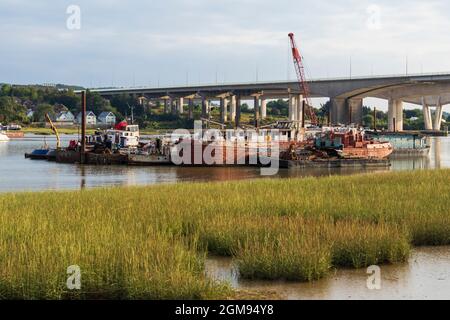 Low Tide, am späten Nachmittag Medway Estuary in Rochester in Kent mit Bootsreparatoren schwimmende Dock im Bild mit M2 Medway Bridge im Hintergrund Stockfoto