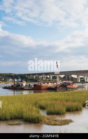 Low Tide, am späten Nachmittag Medway Estuary in Rochester in Kent mit Bootsreparatoren schwimmende Dock im Bild mit M2 Medway Bridge im Hintergrund Stockfoto