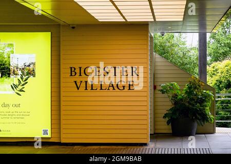 Bicester, Oxfordshire, England - 2021. Juni: Schild am Eingang des Bicester Einkaufsdorfes Outlet Mall Stockfoto