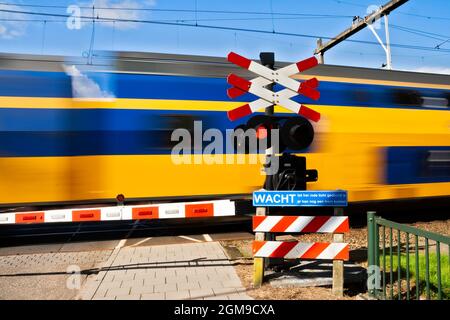 Hochgeschwindigkeitszug, der einen Bahnübergang in den Niederlanden passiert Stockfoto
