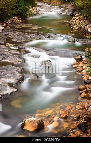 Langzeitaufnahme eines Flusses im rat von aller in Asturien.das Foto ist in vertikalem Format aufgenommen und das Wasser erscheint mit dem Seideneffekt Stockfoto