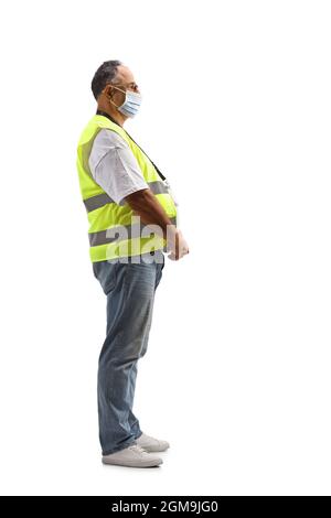 Ganzkörperaufnahme eines reifen Mannes mit Gesichtsmaske und reflektierender Sicherheitsweste auf weißem Hintergrund Stockfoto