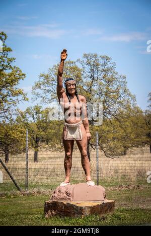 05-14-2020 Bartlesville USA - Statue des indianischen Mannes mit Lendenschurz und Stirnband, die die Hand hebt und vor dem Woolaroc Museum und Wild Animal begrüßt Stockfoto