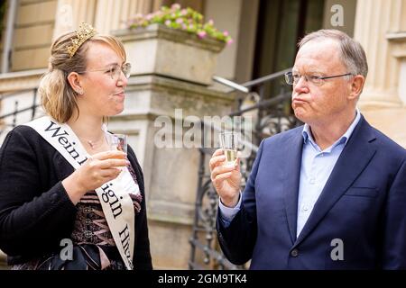 Hannover, Deutschland. September 2021. Lina Fürch, Weinkönigin von Hitzacker, verkostet Wein mit Stephan weil (SPD), Ministerpräsident von Niedersachsen, bei einem Empfang für Ernte- und Produktkönige und -Königinnen im Garten des Gästehauses der Niedersächsischen Landesregierung. Quelle: Moritz Frankenberg/dpa/Alamy Live News Stockfoto