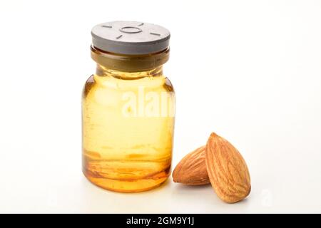Mandelöl in Flasche isoliert auf weißem Hintergrund, Makro. Stockfoto