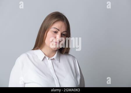 Traurige übergewichtige junge Frau Porträt. Unglückliche weiße kaukasische Frau im Studio. Gut aussehendes und großes Modell, das Traurigkeit ausdrückt Stockfoto