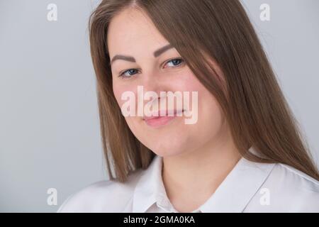 Schöne übergewichtige junge Frau lächelt in der Kamera auf Studioportrait. Plus Size weibliche Porträt. Stockfoto