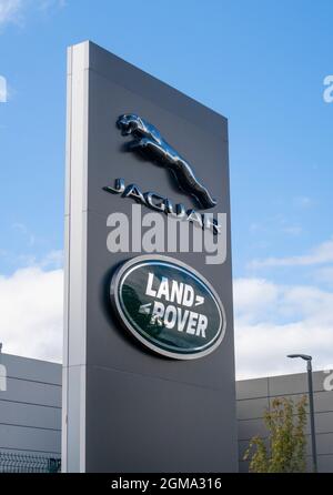 Jaguar Land Rover Fahrzeuglogo und Schild vor dem Ausstellungsraum des Autohändlers, Exeter Stockfoto