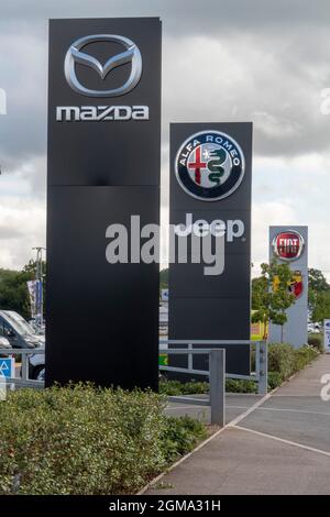 Reihe von Autohändlern in Exeter - Mazda, Jeep, Alfa Romeo und Fiat Auto-Logo und Zeichen vor Autohändler Showrooms, Exeter Stockfoto