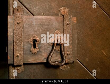 Antikes rostliches Schloss an einer mittelalterlichen Holztür Stockfoto