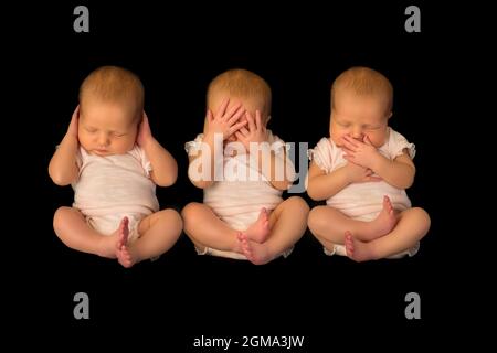 Ein Baby posiert dreimal, um dem Sprichwort zu zeigen, hören sehen, sprechen kein Böses Stockfoto