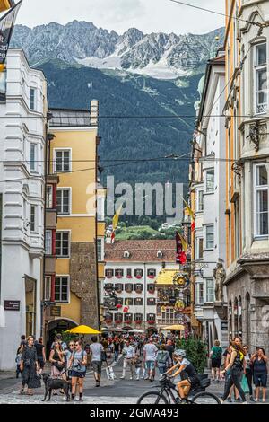 Flanierende Touristen besuchen das Goldene Dachl, das Goldene Dachl und die malerisch geschmückten Häuser in der Herzog-Friedrich-Straße. Innsbruck, Tirol, Österreich Stockfoto