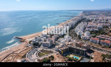 Schöne Luftbilder der portugiesischen Touristenstadt Quarteira. An der Küste während der Strandsaison mit Touristen, die sich sonnen. Stockfoto