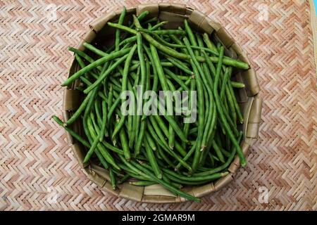 Grüne lange Bohnen auch als frische Lobia KI phalli oder Chawli Haufen in Korbkorb bekannt. Draufsicht auf dünne indische Bohnen Bio frisch geerntet Stockfoto