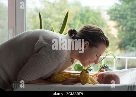 Kaukasische Mutter ändert Baby Mädchen sauberes Tuch Stockfoto