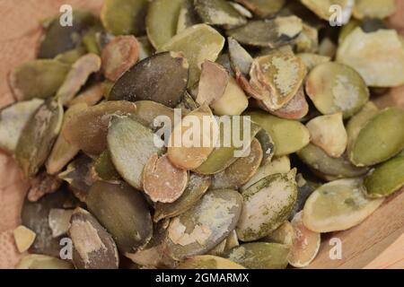 Kürbiskerne in einer Holzschale auf weißem Hintergrund. Gewürze. Stockfoto