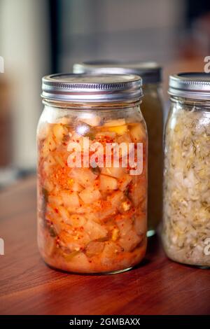 Köstliche fermentierte Kimchi und Sauerkraut in Maurergrüsern Stockfoto