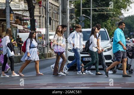 Bukarest, Rumänien - 13. September 2021: Fußgänger überqueren die Straße auf dem Regina Elisabeta Boulevard in Bukarest, Rumänien. Stockfoto